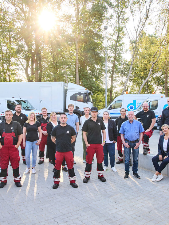 Teamfoto abfluss ass dröge vor Fahrzeugen